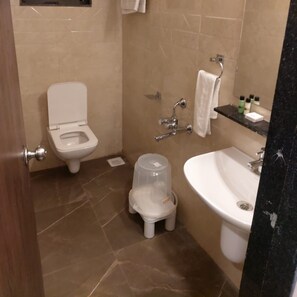 A bathroom with a toilet, a sink, and a shower area. - Chandan Van Club and Resort - Navsari (Navsari)
