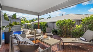 A modern outdoor living space with a pool, comfortable seating, and a view of the neighborhood. - Oasis at Sapphire,Pool, Pet Friendly, Bike Paths, Family Fun (Sapphire Beach)