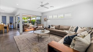 A spacious living room with a large sofa, a coffee table, and a dining area with a table and chairs. - Oasis at Sapphire,Pool, Pet Friendly, Bike Paths, Family Fun (Sapphire Beach)