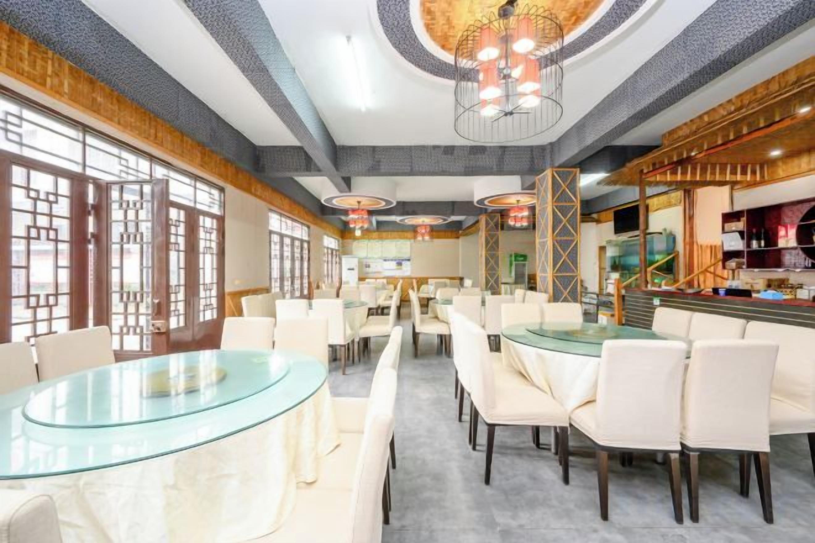 A restaurant with round tables, chairs, and a bar area.
