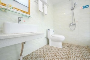A bathroom with a white sink, toilet, and shower.