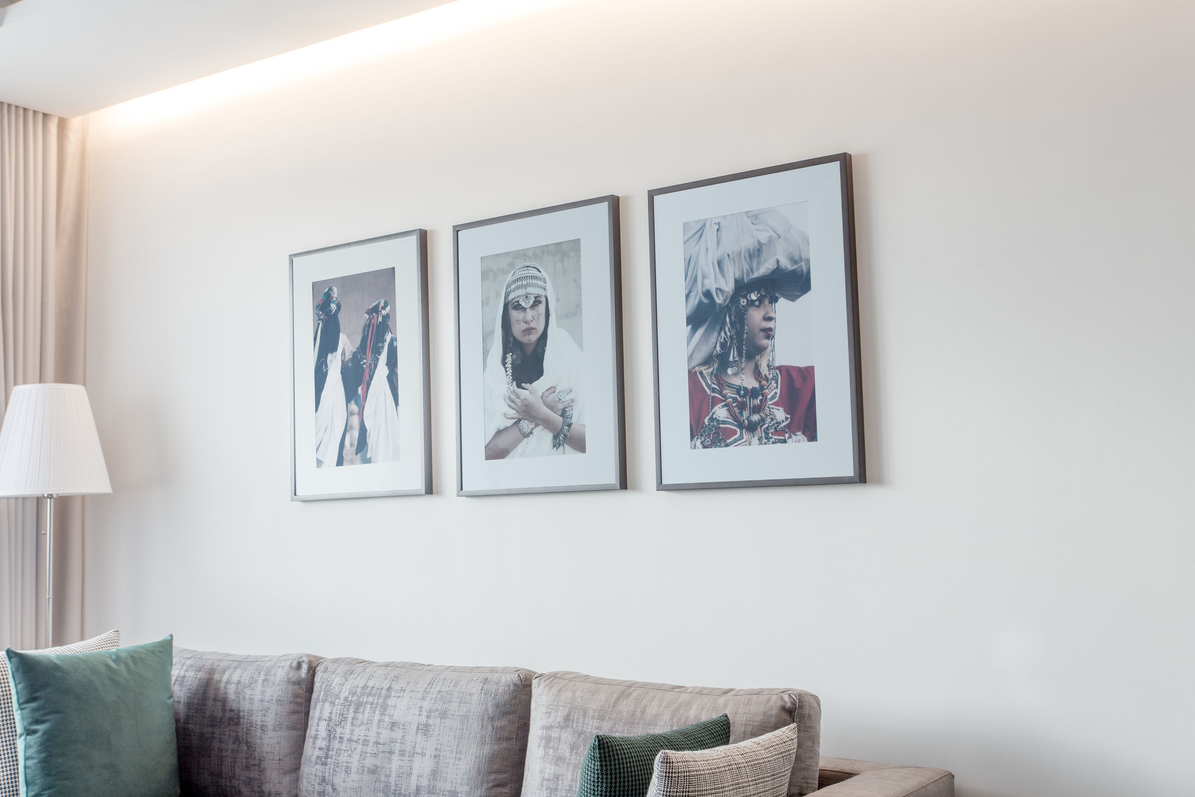 A living room with a sofa and three framed pictures on the wall.