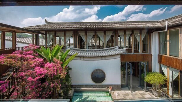 Un edificio de estilo tradicional con patio, piscina pequeña y vistas al cielo.
