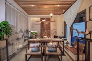 Un espace repas comprenant une table en bois, des chaises et un luminaire suspendu.
