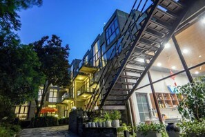 A multi-level building with a staircase connecting different floors, surrounded by greenery.