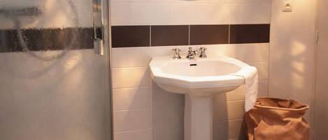 A bathroom with a white sink, a mirror, and a towel rack.