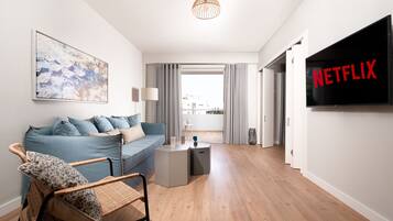 Habitación cuádruple de diseñador | Área de sala de estar | Televisión