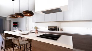 A modern kitchen with a central island, built-in appliances, and pendant lighting. - Blue Avra by A&D Properties (Markopoulo Mesogaias)