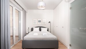 A modern bedroom with a bed, bedside tables, a lamp, and a wardrobe. - Blue Avra by A&D Properties (Markopoulo Mesogaias)