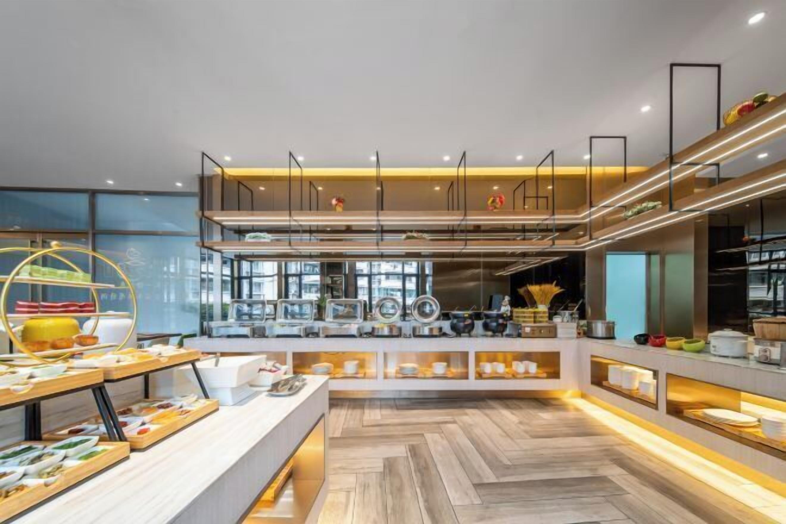 A modern kitchen with a central island, upper and lower counters, and a herringbone wood floor.