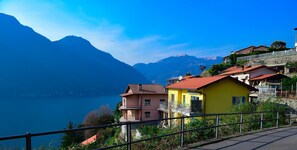 Un village côtier avec des maisons construites sur une colline, d’où l’on a vue sur un lac et des montagnes.