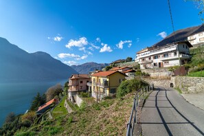 Un quartier résidentiel situé sur une colline, avec des maisons offrant une vue sur un lac et des montagnes.