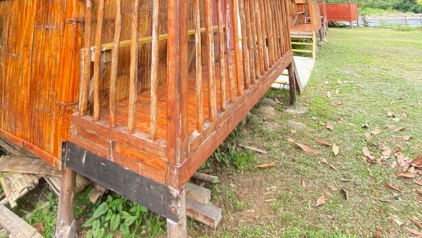 Una estructura de madera con un porche y un techo de metal.