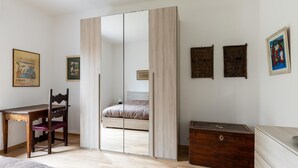 A bedroom with a bed, a wooden desk, a chair, a wardrobe, and a dresser. - Casa con Giardino a Borgo Panigale (Bologna)