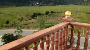 A balcony with a view of a green landscape and a road. - Langshan Patriotic Farm (Xinning)