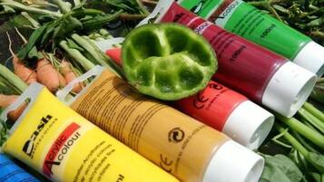 Tubes of acrylic paint and vegetables.