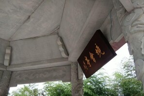 A stone structure with carved details and a hanging sign with gold lettering. - Huzhou Biocountry Resort (Changxing)