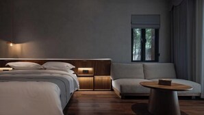 A modern bedroom with a bed, bedside tables, a sofa, and a round coffee table. - Huzhou Biocountry Resort (Changxing)