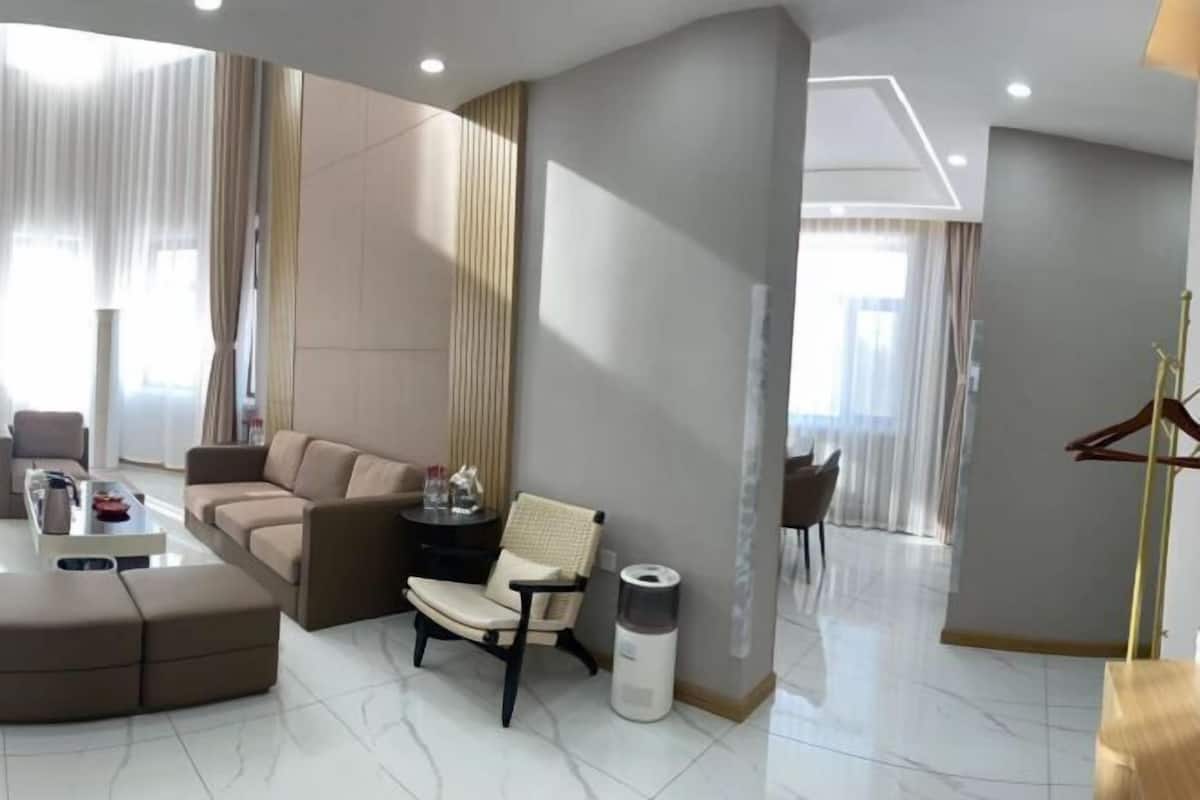 A modern living room with a sofa, armchair, coffee table, and a small side table.
