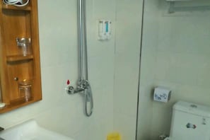 Une salle de bain avec une douche, des toilettes et un lavabo.