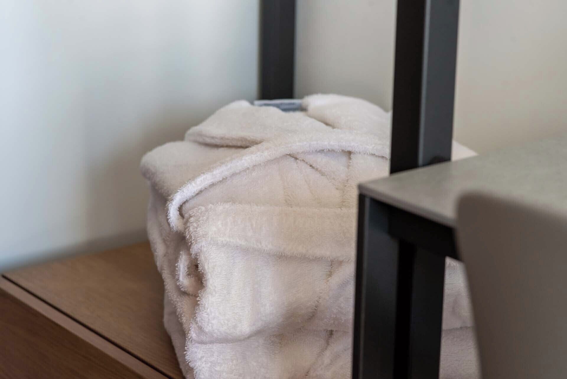 A white bathrobe draped over a chair.