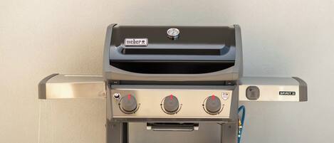 Una parrilla Weber Spirit II con tres perillas de control y una pantalla digital.
