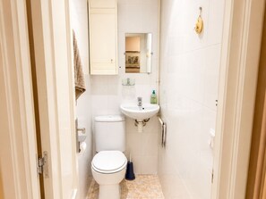 Un bagno piccolo con il water, un lavandino e uno specchio.