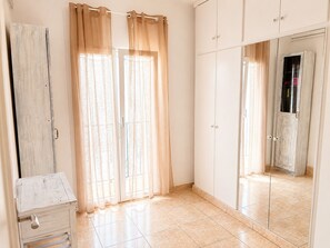 Una habitación con una puerta corrediza de vidrio, un armario y un espejo.
