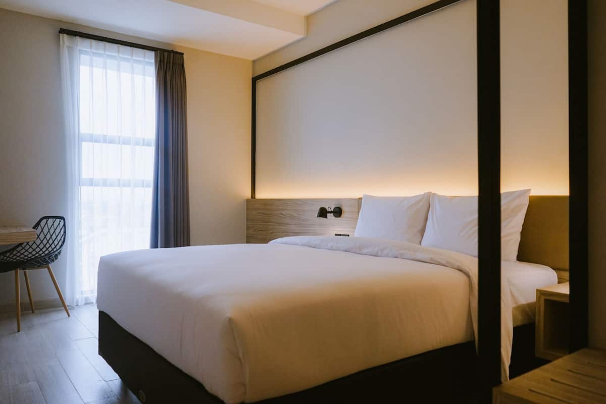 Una habitación de hotel con una cama grande, un escritorio y una silla.