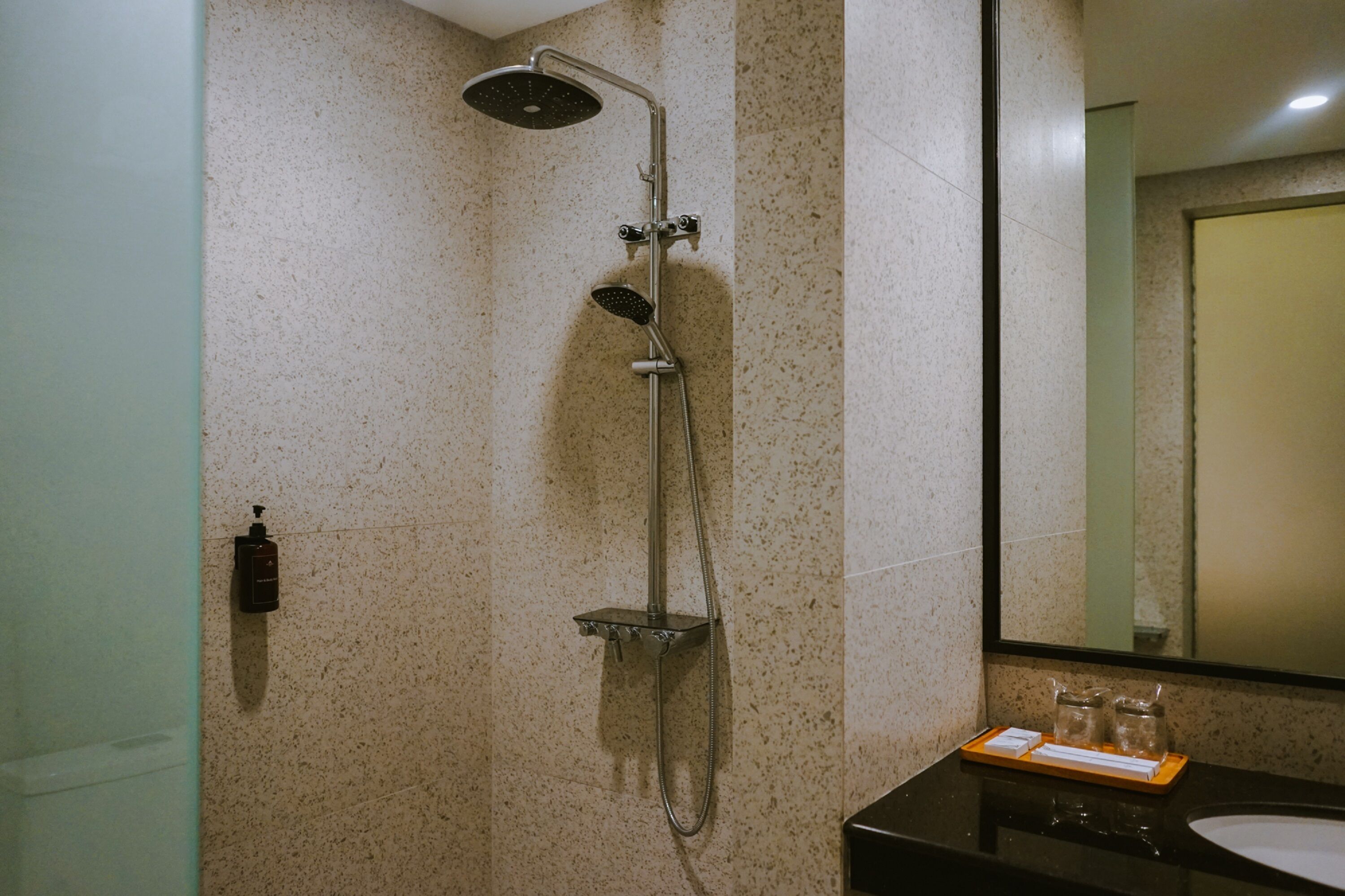 Un baño con ducha, lavabo y espejo.