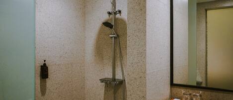 Un baño con ducha, lavabo y espejo.
