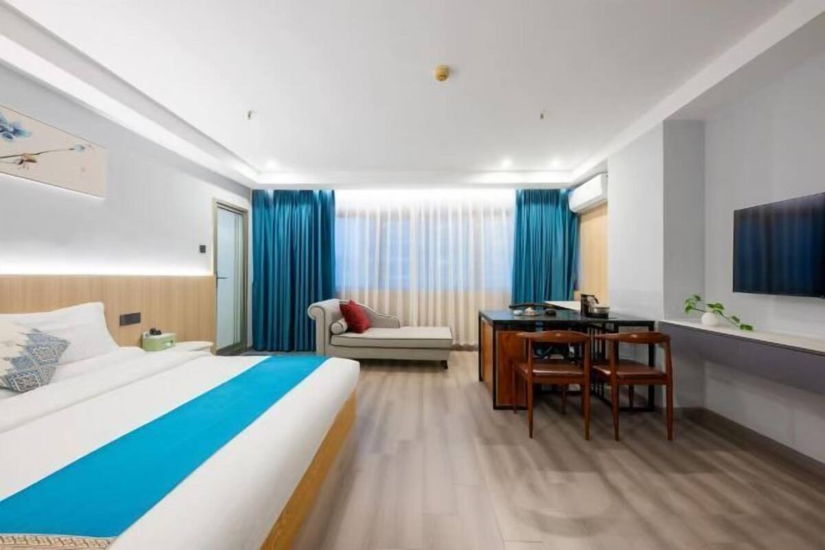 A hotel room with a bed, a desk, and a chair.