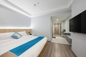 A modern hotel room with a large bed, a flat-screen TV, and a walk-in closet. - Chongqing Hotel (Shenzhen Luohu Port Guomao Subway Station) (Shenzhen)