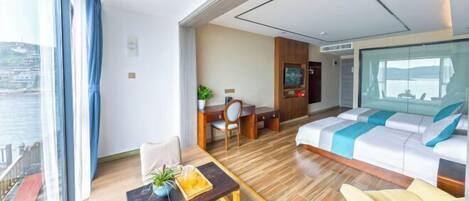 A modern hotel room with a balcony, a dining area, a sofa, and a bed.