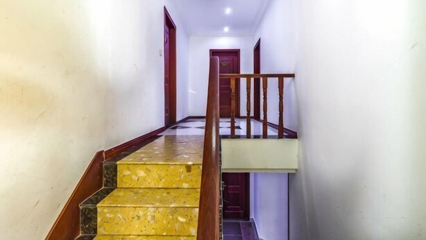 Un pasillo con una escalera que lleva a una puerta al final.