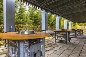 An outdoor patio with tables and a grill.