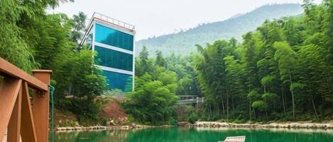 Una barca de madera en un río tranquilo, con un edificio moderno al fondo.