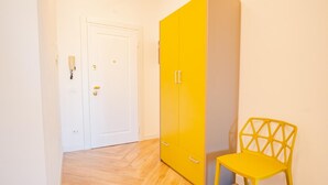 A room with a white door, a yellow wardrobe, and a yellow chair. - The Roman Villa View - Italian Homing (Desenzano del Garda)