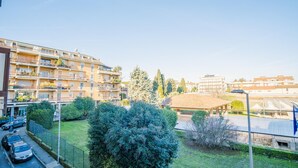 A residential area with multi-story apartment buildings, a covered outdoor seating area, and a parking lot. - The Roman Villa View - Italian Homing (Desenzano del Garda)
