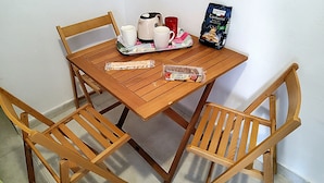 A wooden table with a tray of food items, including cookies and a bag of biscotti, and a coffee maker. - Economy Apartment 12 Sleeps 3 Guests (Split)