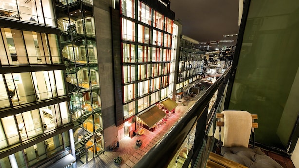 Un edificio moderno con varios pisos, ventanas amplias y fachada de vidrio.