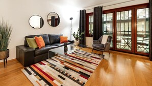 Una sala de estar moderna con un sofá de cuero, una mesa de centro de vidrio y un tapete a rayas.