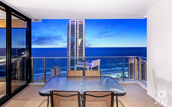 Enjoy ocean views from the balcony with a glass table and two chairs.