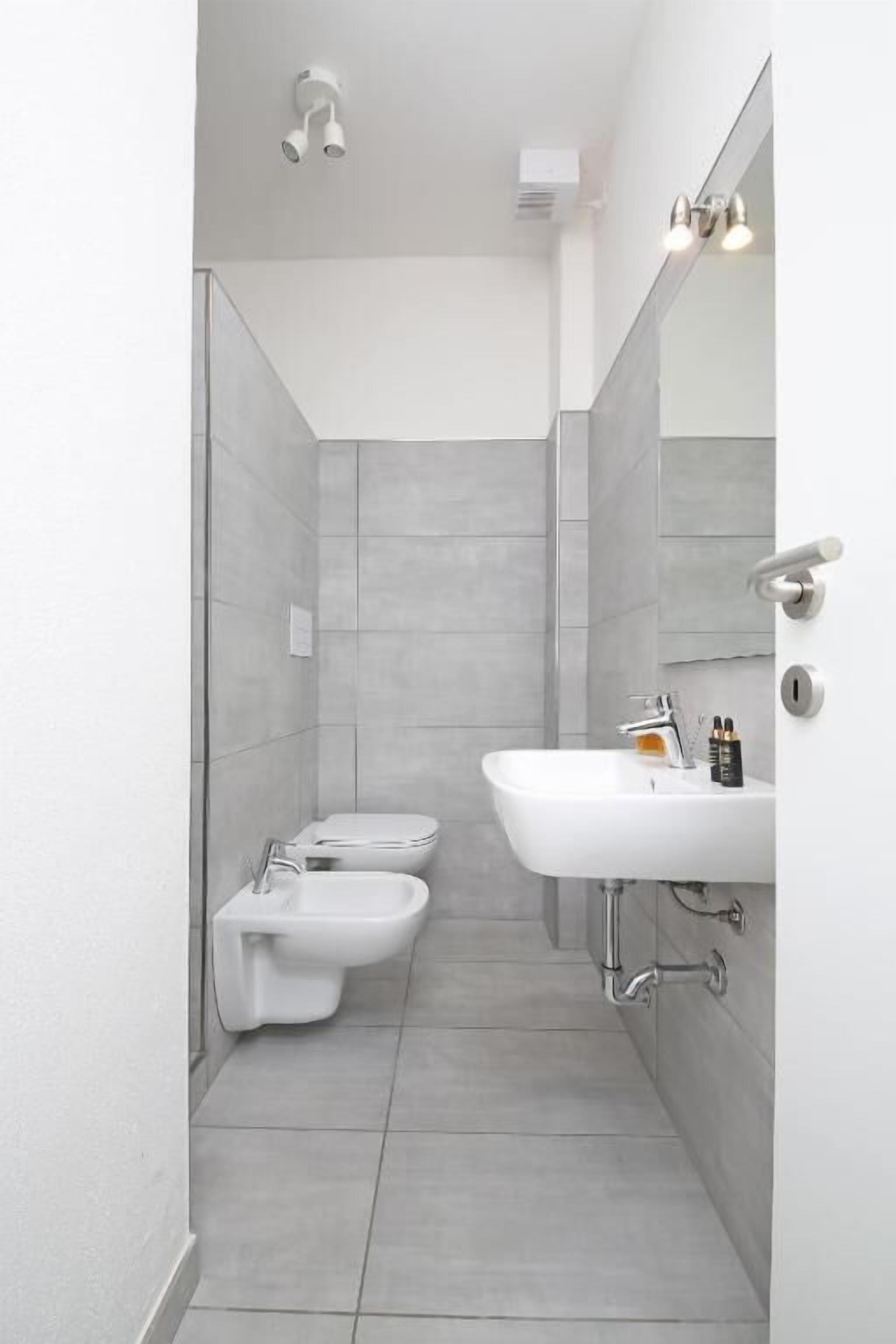 A modern bathroom with a toilet, bidet, and sink.