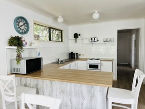 Enjoy cooking in this well-equipped kitchen with a central island, microwave, oven, and sink.