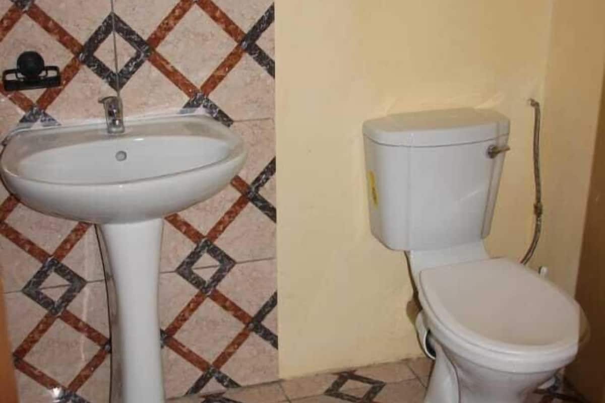 A bathroom with a white sink, toilet, and patterned floor tiles.