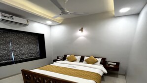 A modern bedroom with a bed, nightstands, a ceiling fan, and a large window.