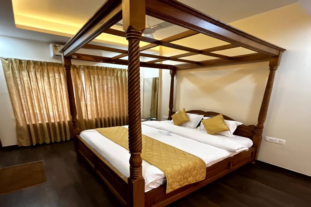 Una cama con dosel de madera y una colcha acolchada.