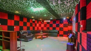 A room with a checkered wall pattern, a leather sofa, a wooden coffee table, and a bookshelf. - Boxi Haiyun Hot Spring Holiday Villa (Huizhou)