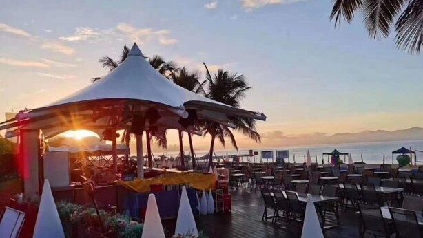 A beachside restaurant with outdoor seating, a covered area, and a view of the sea. - Boxi Haiyun Hot Spring Holiday Villa (Huizhou)